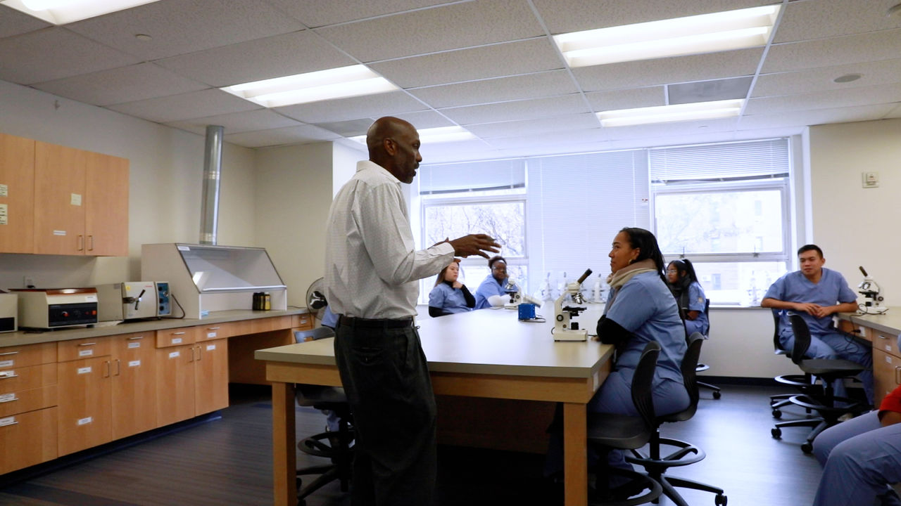 Science instructor teaching students in laboratory classroom